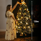 Woman reaching toward the star topper of a 1.8m prelit Christmas tree with height measurement marker showing 1.8 metres