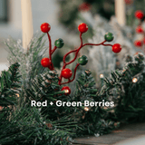 Close-up of red and green berry clusters on a snow-flocked Christmas garland
