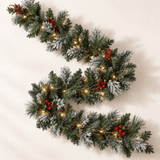 1.8m snow-flocked pine garland with warm white LEDs and red and green berry clusters