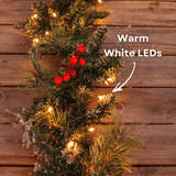 Close-up of a warm white LED light nestled in a snow-flocked pine garland