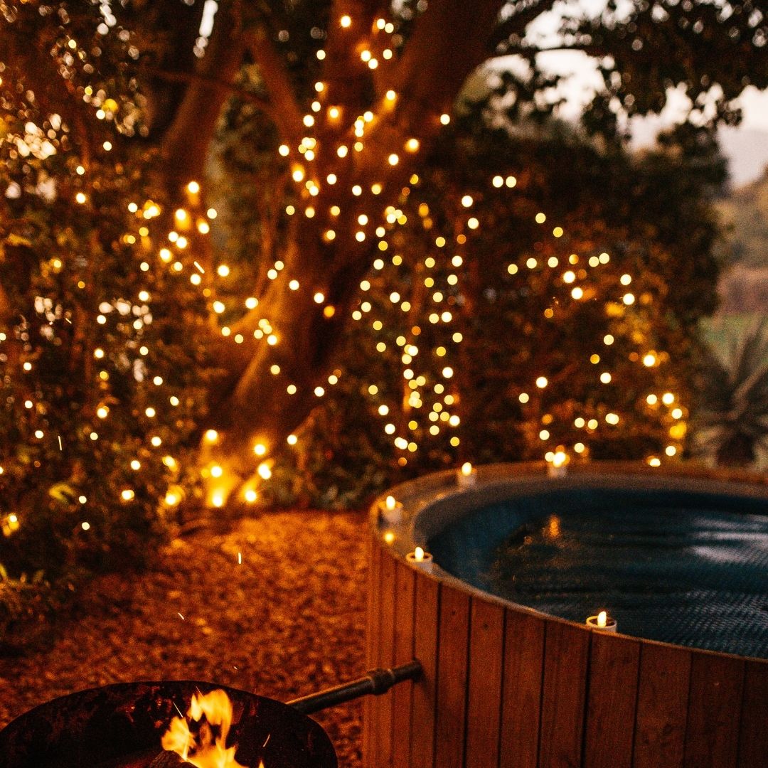 Solar Fairy Lights hung in a hedge next to a outdoor hottub creating a cozy and romantic environment.