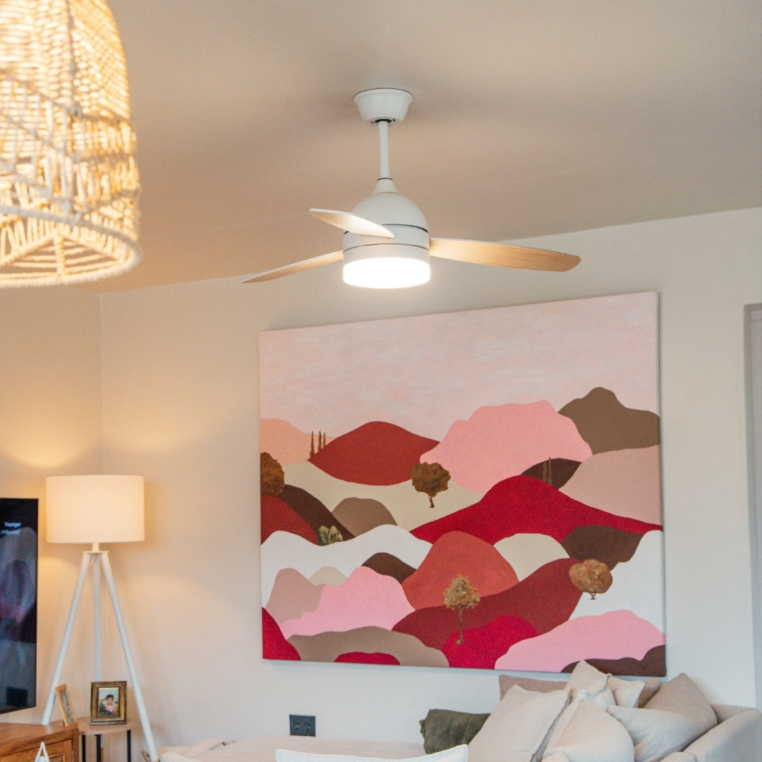 42 inch reversible wood and white blade ceiling fan installed in a modern South African boho lounge with warm white light glowing and three reversible blades