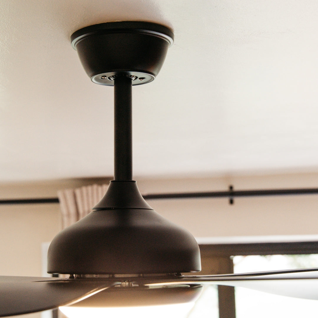 Close-up of 52 inch matte black ceiling fan motor body and integrated tri-colour LED light kit detail from below