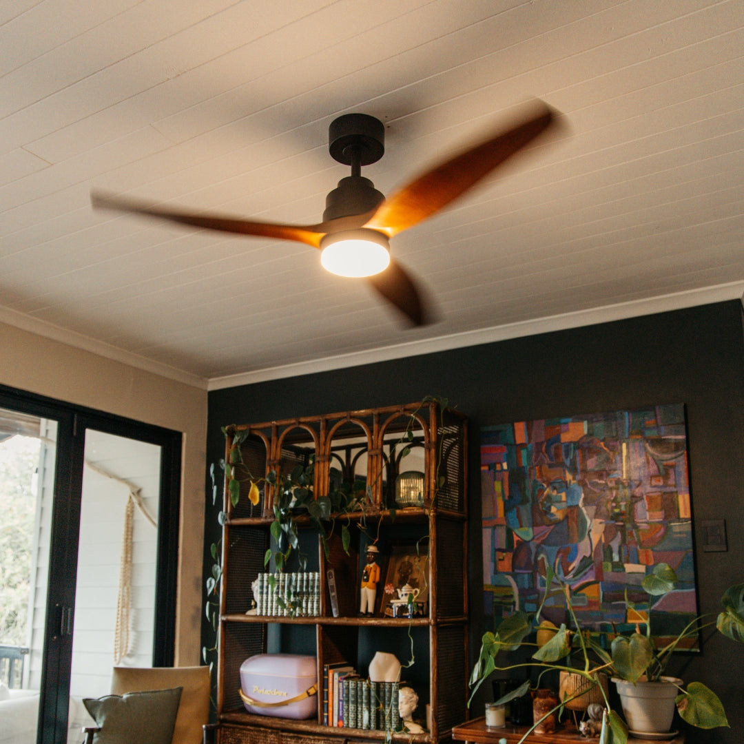 52 inch dark oak wood blade ceiling fan installed on ceiling with motor running, three real oak wood blades spinning, and integrated LED light glowing warm white