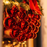 Close-up of glossy red baubles clustered on a luxury Christmas wreath