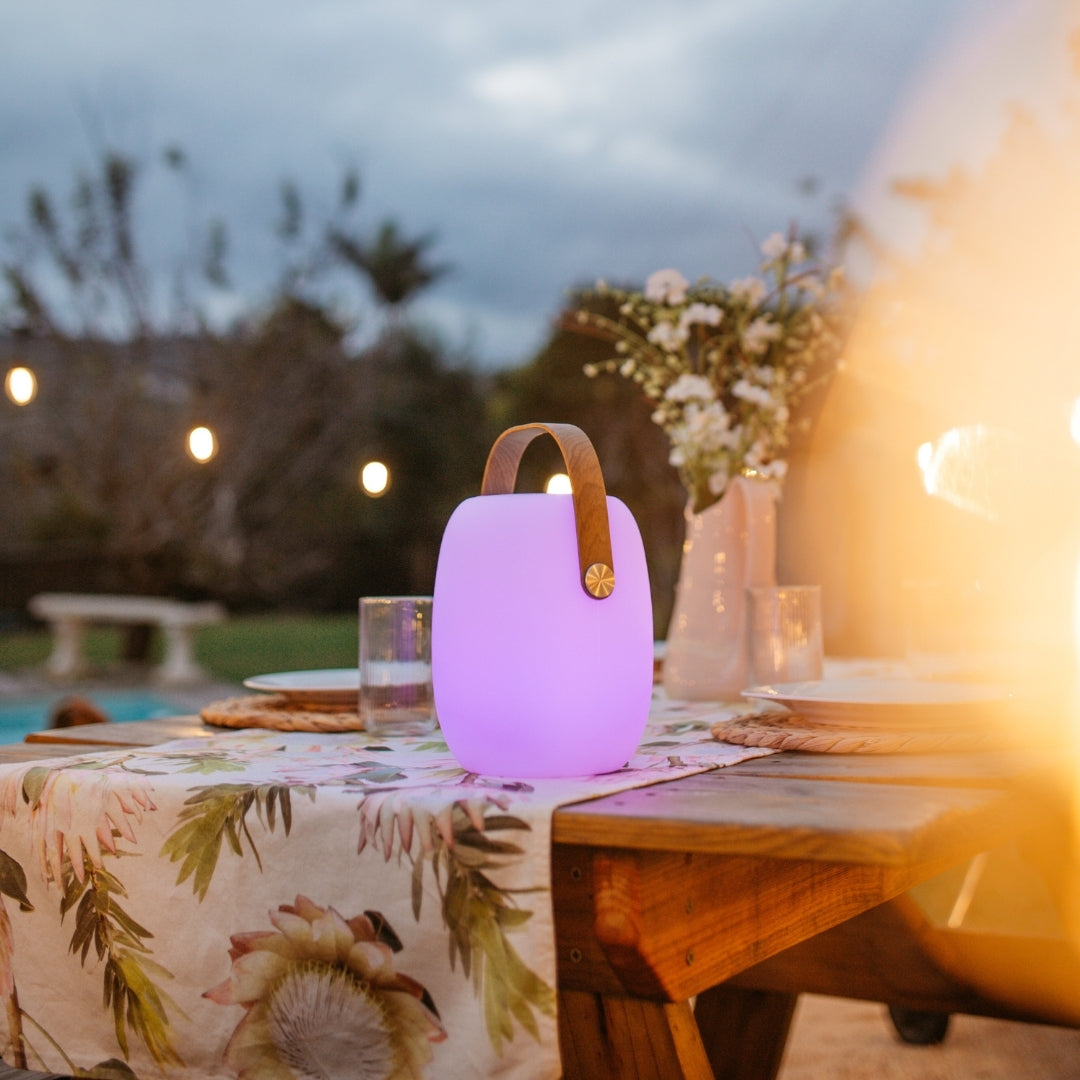 Bluetooth RGB speaker lantern glowing purple on a table