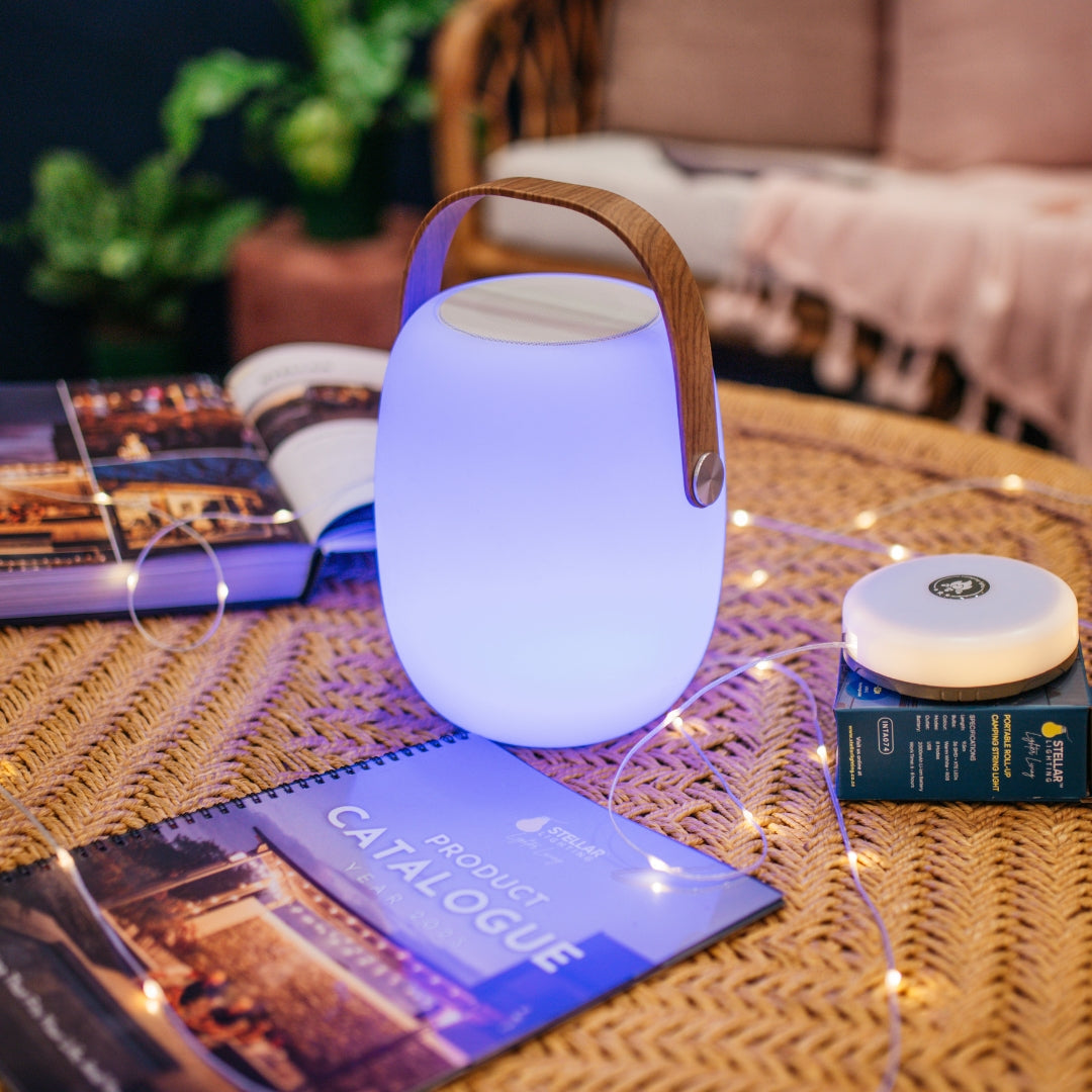 Bluetooth Speaker Lantern glowing warm white indoors on a bedside table or kitchen counter during a load-shedding evening