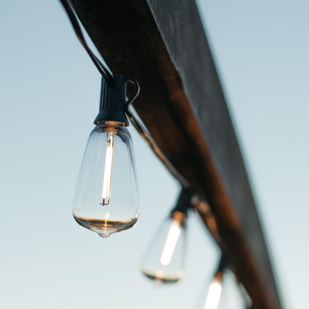 ST38 vintage LED replacement bulbs glowing warm white on black string lights strung outdoors
