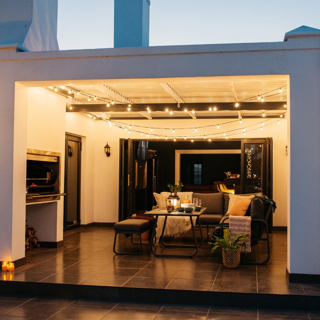 Classic String Lights with 25 warm white G40 globe bulbs strung across a South African covered patio or lapa at dusk creating a warm golden glow