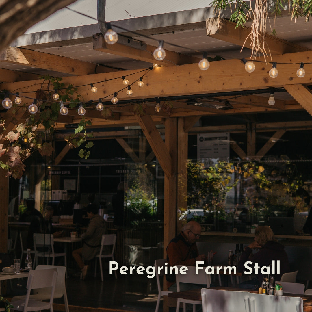 Classic String Lights Pro strung beneath a wooden pergola roof at Peregrine Farm Stall with customers seated below