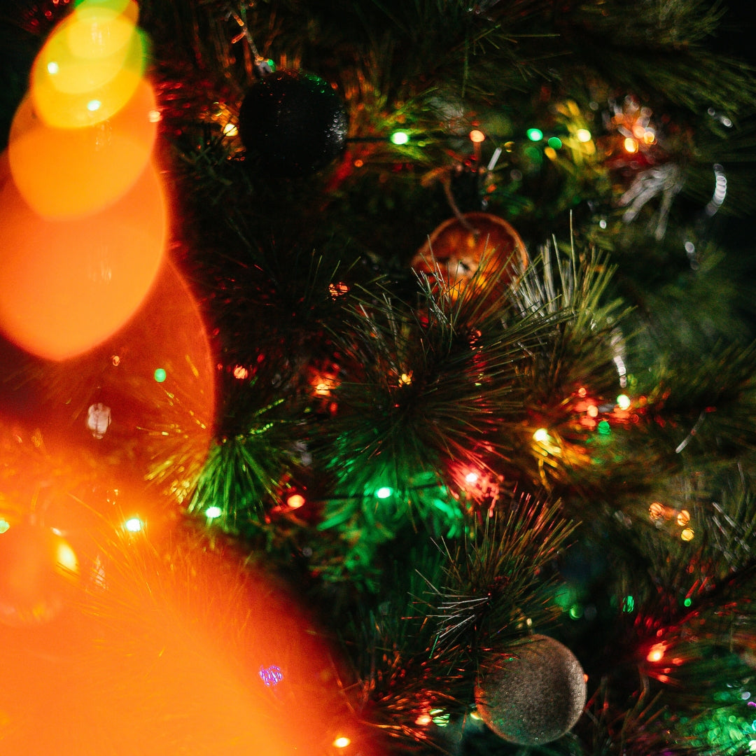 Decorated Christmas tree with colourful lights and ornaments, blurred lights in the background
