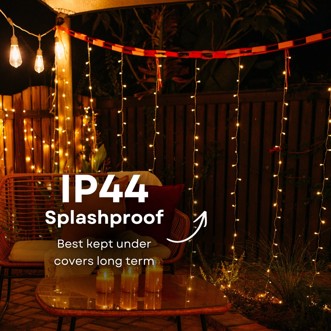 Outdoor setting with curtain fairy lights and a table, featuring IP44 splashproof text.