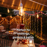 Outdoor setting with curtain fairy lights, chairs, and a table with candles and food, perfect for weddings, gardens, and patios.