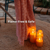 Set of three domed glass flameless LED candles glowing safely next to fabric on a jute rug with flame-free and safe callout