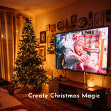 Living room with Christmas tree and fairy lights and a TV showing Home Alone, with text 'Create Christmas Magic'.