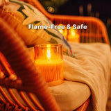 Candle in a glass holder on a wicker chair with 'Flame-Free & Safe' text overlay.
