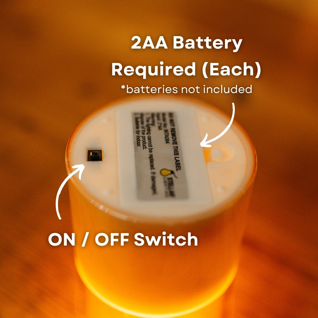 Close-up of flameless candle with a 2AA battery requirement and on/off switch on a warm background.