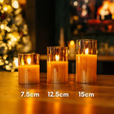 Three candles of different heights on a table with a blurred festive background