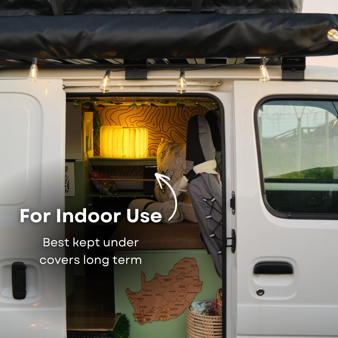 Foldable LED book light glowing inside a camper van interior with text indicating indoor use