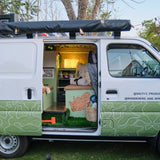 Foldable LED book light visible inside a decorated camper van with open side door during the day