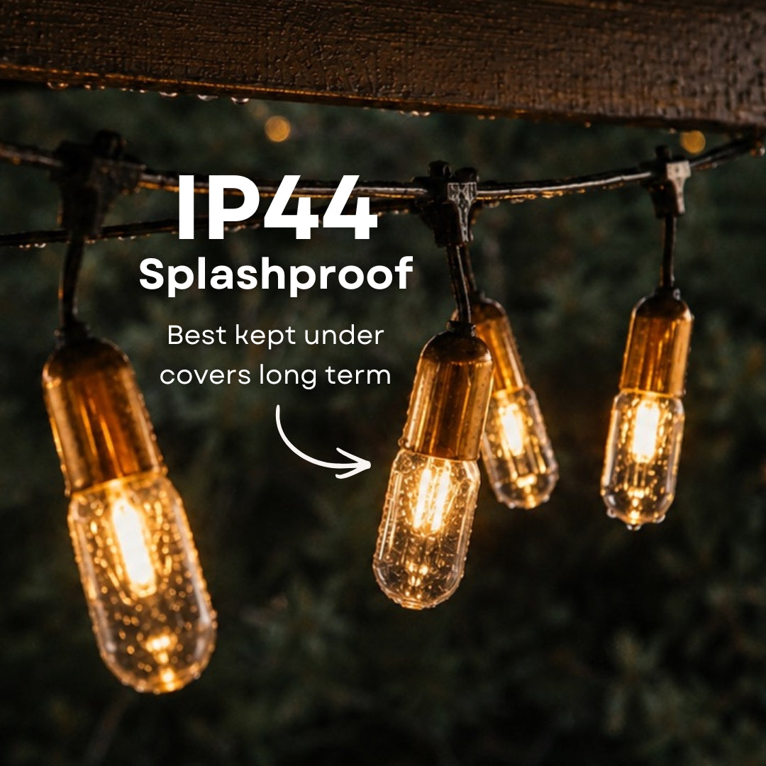 String of gold drop string lights with IP44 splashproof text on a dark background