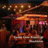 People gathered at a outdoor event with 'Shackleton' branding under Stellar Lighting string lights.