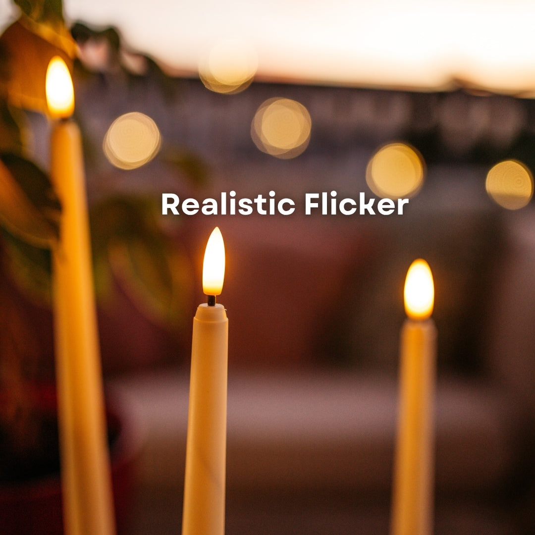 Close-up of warm amber LED realistic flicker on ivory flameless taper candles at dusk with bokeh background