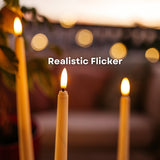 Close-up of warm amber LED realistic flicker on ivory flameless taper candles at dusk with bokeh background