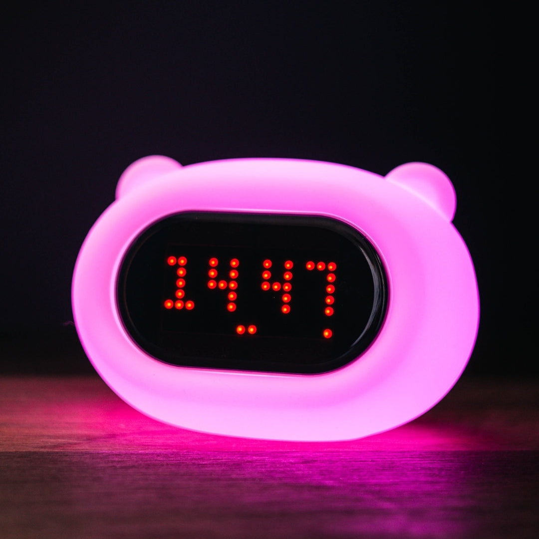 Lightie Clock bear silicone kids night light glowing softly on a bedside table in a children's room