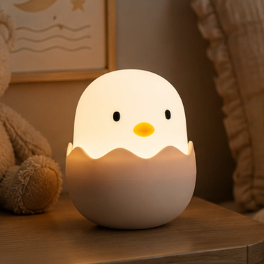 Lightie Egg silicone kids night light glowing warm white on a bedside table in a softly lit children's room