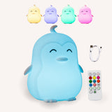 Lightie Penguin silicone night light shown in four colour modes including warm white, blue, pink, and purple with USB charging cable and remote control included