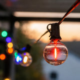 Multicolour Classic String Lights with 25 multicolour G40 globe bulbs on black cable glowing in a styled South African outdoor space creating a festive colourful atmosphere