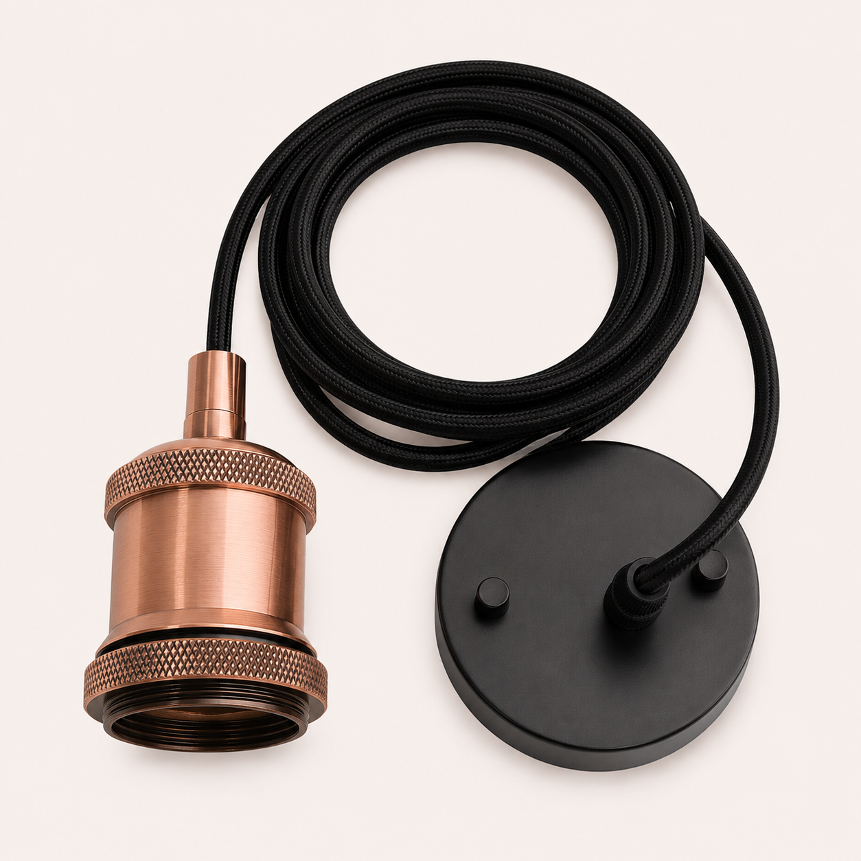 Close-up of copper pendant light fitting with knurled detail and black braided cable on a light background