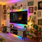 Rainbow RGBIC LED strip lighting behind a TV and media console in a living room