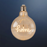 Single G125 globe LED bulb with HOME filament detail and clear glass on a dark navy background