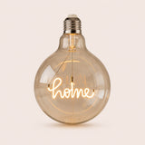 Single G125 globe LED bulb with HOME filament detail and clear glass on a light background
