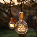 G125 globe LED bulb with warm white hearts filament glowing softly in an interior pendant fitting