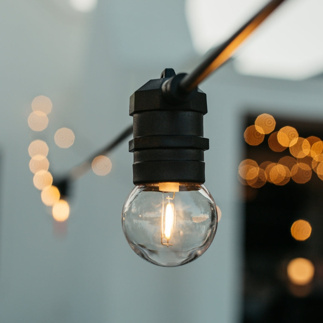 G45 globe LED replacement bulbs glowing warm white on outdoor festoon string lights