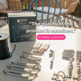 A Stellar Lighting Setup Kit components laid out on a table outdoors, including a black spool of wire, the product box, and various silver metal hardware components. A pink badge with a happy customer quote is overlaid on the image.