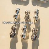 Six metallic double rope clamps arranged on a light beige surface with strong sunlight and shadows. White text overlay reads 'Double Rope Clamps'.