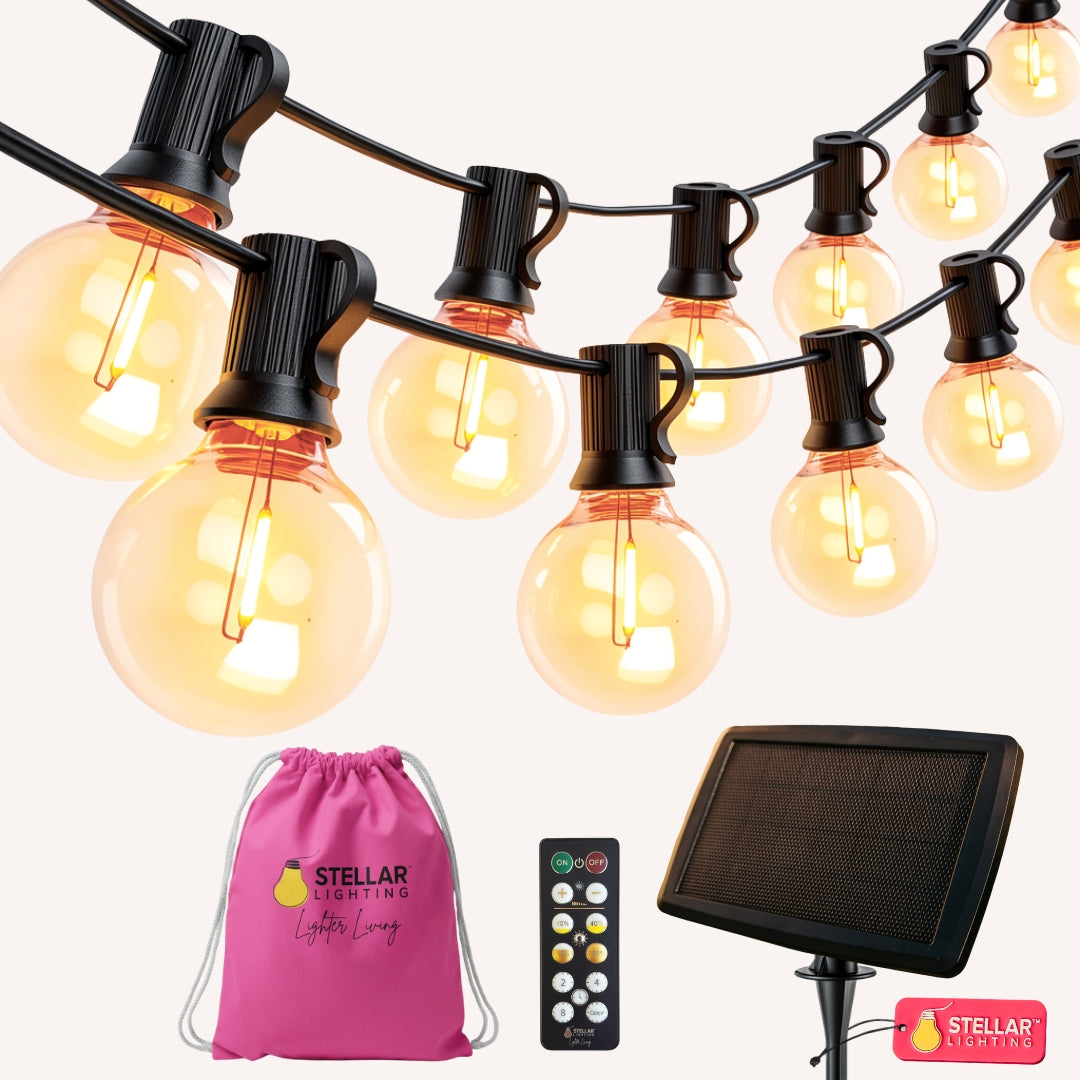 Solar Classic String Lights flat lay showing 25 G40 globe bulbs on black cable with ETFE solar panel, RF remote control, and pink Stellar travel bag on a light background