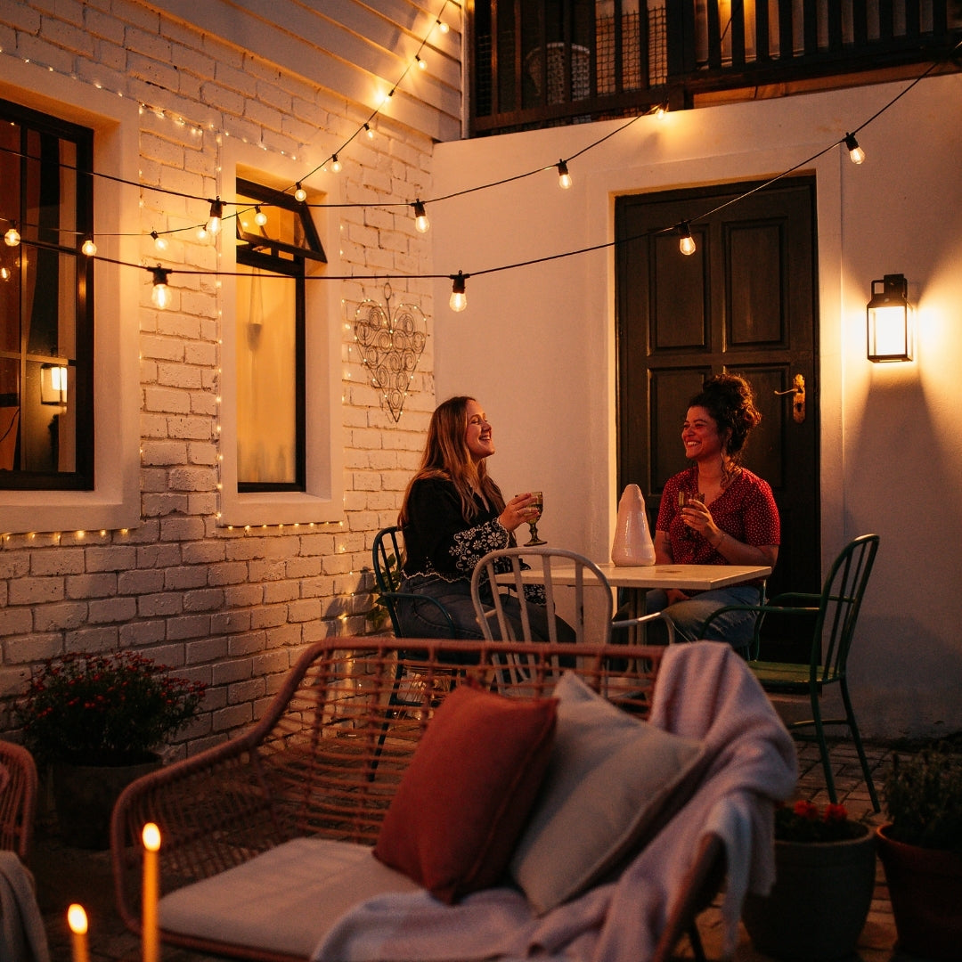 Solar Festoon String Lights with warm white S14 vintage LED bulbs strung across a South African outdoor patio or garden at dusk powered entirely by solar energy