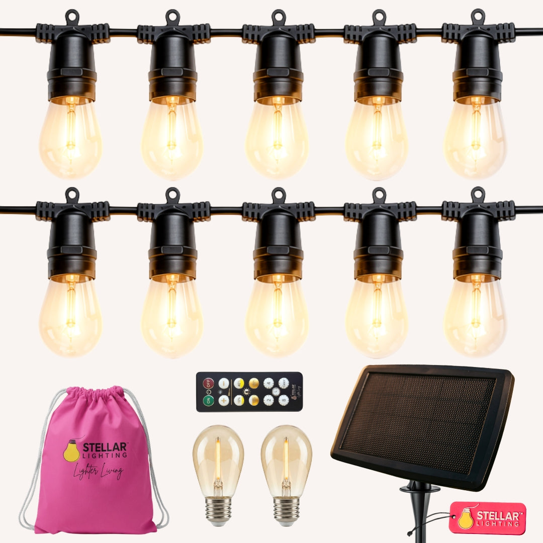 Solar Festoon String Lights flat lay showing warm white S14 vintage LED bulbs on black heavy duty cable with ETFE solar panel on a light background