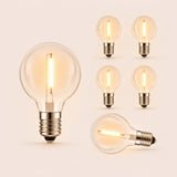 Six solar G40 globe LED replacement bulbs with E12 fitting and warm white filament glow on a light background