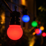 Red light bulb among other colourful lights against a dark background