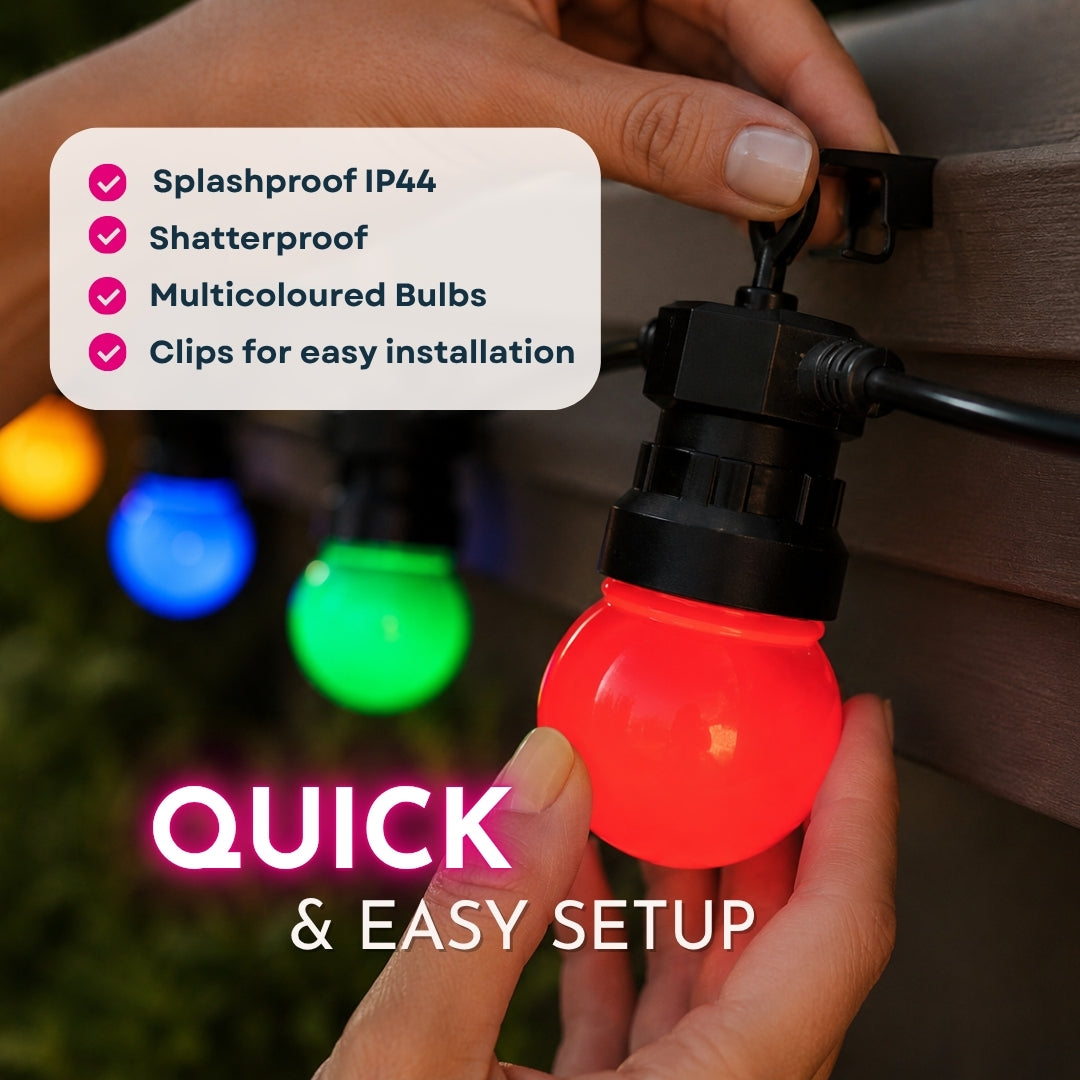 Hand holding a multicolored string light bulb with installation clip, surrounded by other lights on a wooden surface.
