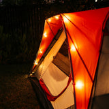 Solar string lights with G40 globe bulbs strung along a camping tent at night with warm amber glow