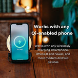 Smartphone resting on black speaker wireless charger with callout text confirming compatibility with any Qi-enabled phone including iPhone 8 and newer and most Android devices