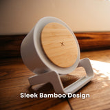 Bamboo and wheat straw speaker wireless charger on wooden surface in natural sunlight showing natural bamboo wireless charging face