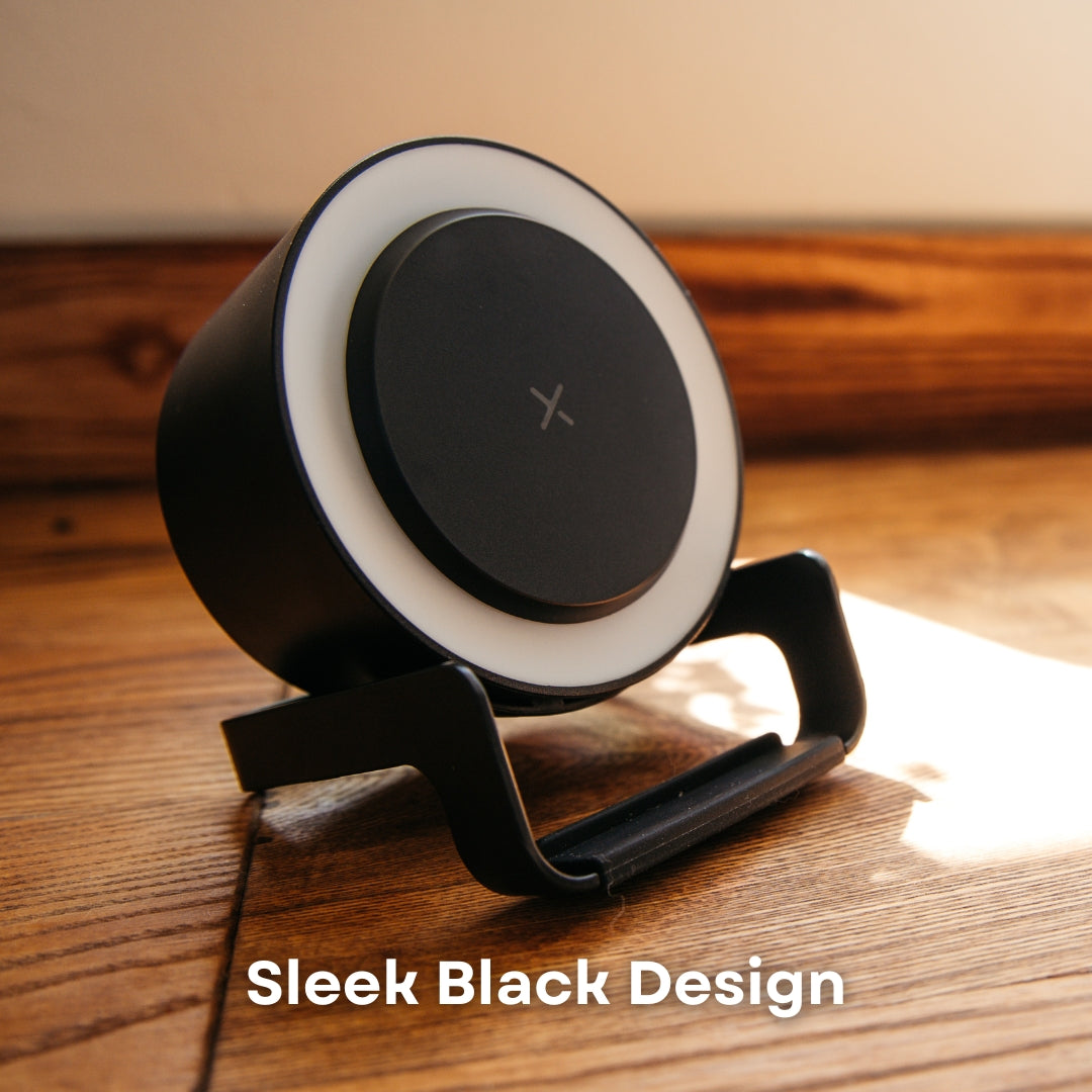 Black speaker wireless charger on wooden surface in natural sunlight showing LED ring detail and phone stand